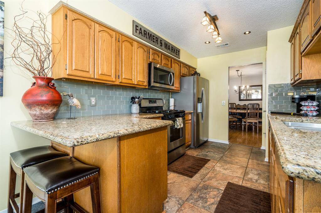 The kitchen is efficient, and yet somehow also has all the space you need to handle daily cooking chores. It overlooks the den and has easy access to the front door for when guests or deliveries arrive.