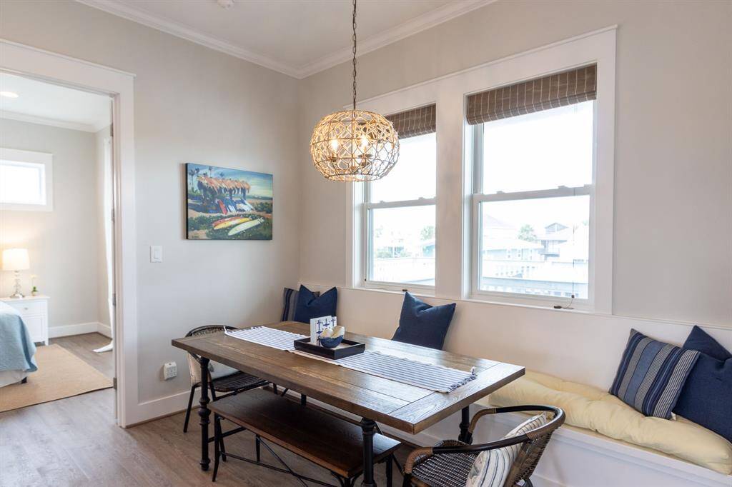 The dining area includes a cozy built in bench beneath two large windows overlooking the deck.