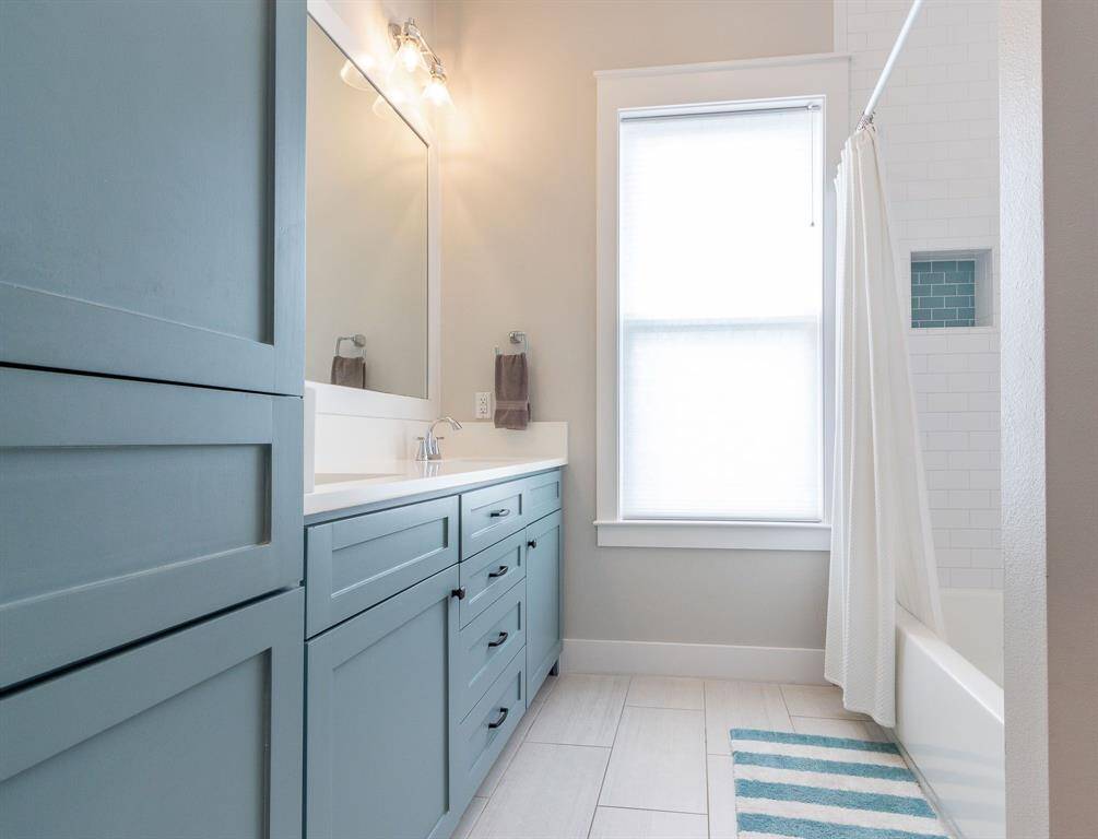Guest bathroom has double sinks with a tiled shower tub combo.  Lots of cabinet space.