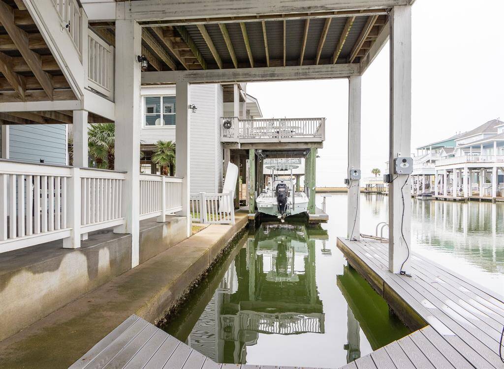 This photo shows a waterfront property with a covered dock area and direct access to a canal. The setting is serene, with neighboring homes featuring similar water access, perfect for boating enthusiasts.