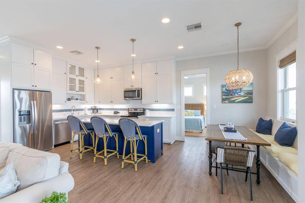 Modern floor plan includes contemporary stainless-steel appliances and quartz countertops. Seating at the breakfast bar.  Bench seat (with storage) and a farmers table.  Lots of natural, bright light.