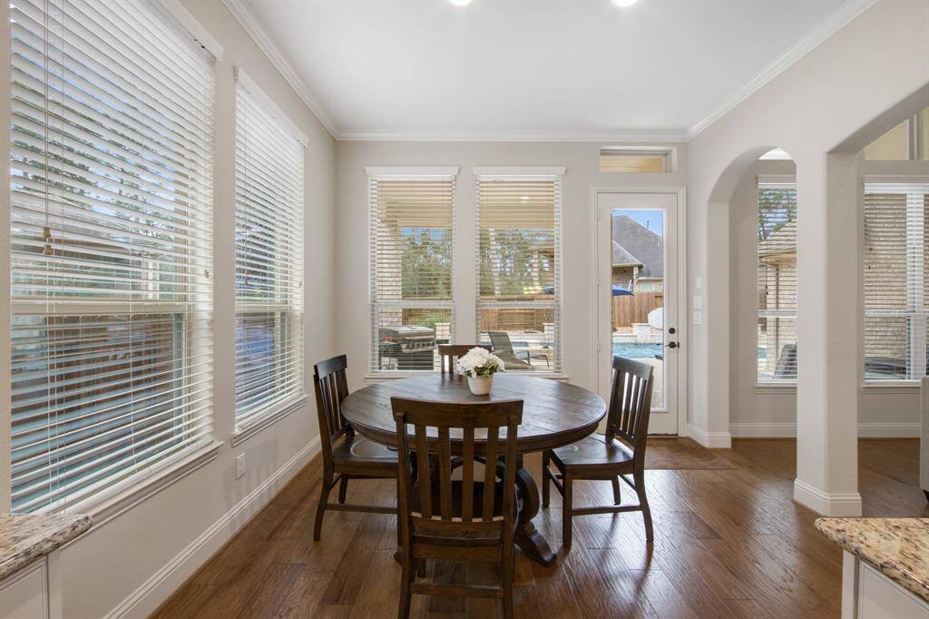 Breakfast room with serene backyard views of the pool, crown molding and walls of windows for an abundance natural light