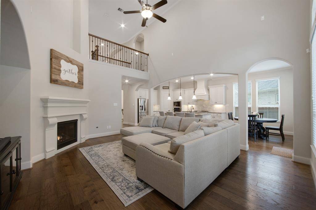 Giant art niche, high ceiling canister lights, 5 blade ceiling fan and crown molding. Iron stair and balusters, stunning wood floors throughout all living areas. Gas log fireplace