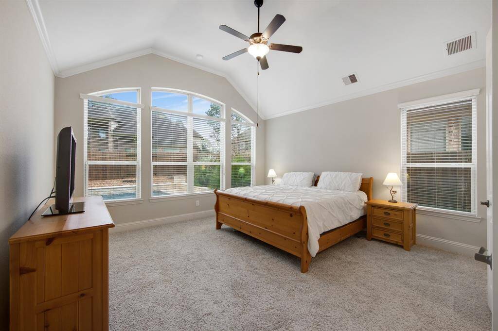Look how spacious the owners retreat bedroom is. Featuring a high ceiling, 5 blade ceiling fan, plush carpeting and relaxing view of the backyard oasis.