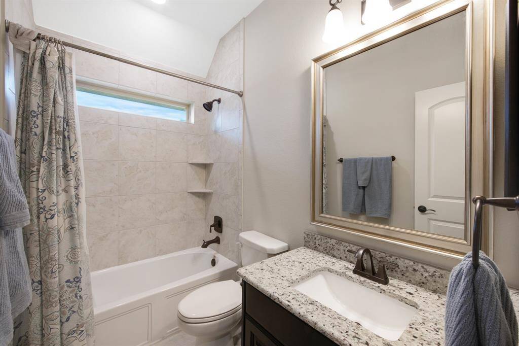 Second upstairs bathroom with tile tub and shower combo, tile flooring, elongated toilet, granite counter sink, designer framed mirror and medicine cabinet