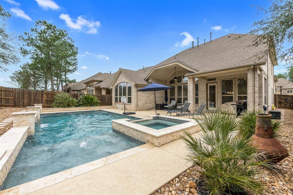 Pool with 4' waterfall, 2 skimmers and 7 return lines. Additional features include a color changing light. and Dolphin robot cleaner. Roomy covered patio and gutters connected to the French drains