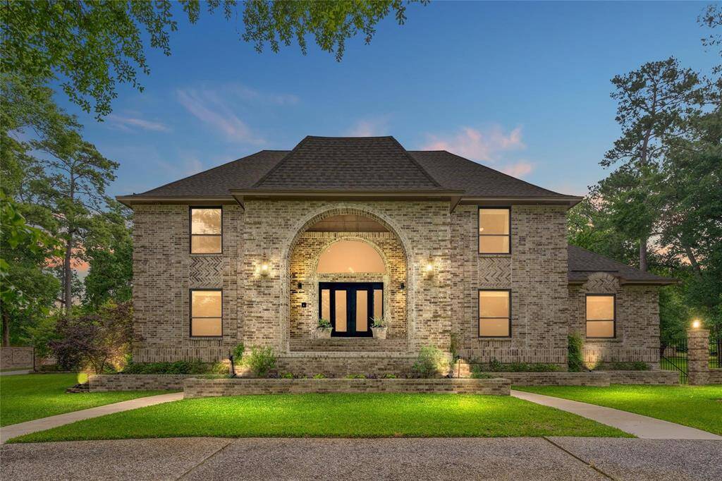Discover elegance in this stunning two-story brick home, featuring a striking arched entryway. Surrounded by lush landscaping and mature trees, it offers a tranquil and inviting setting.