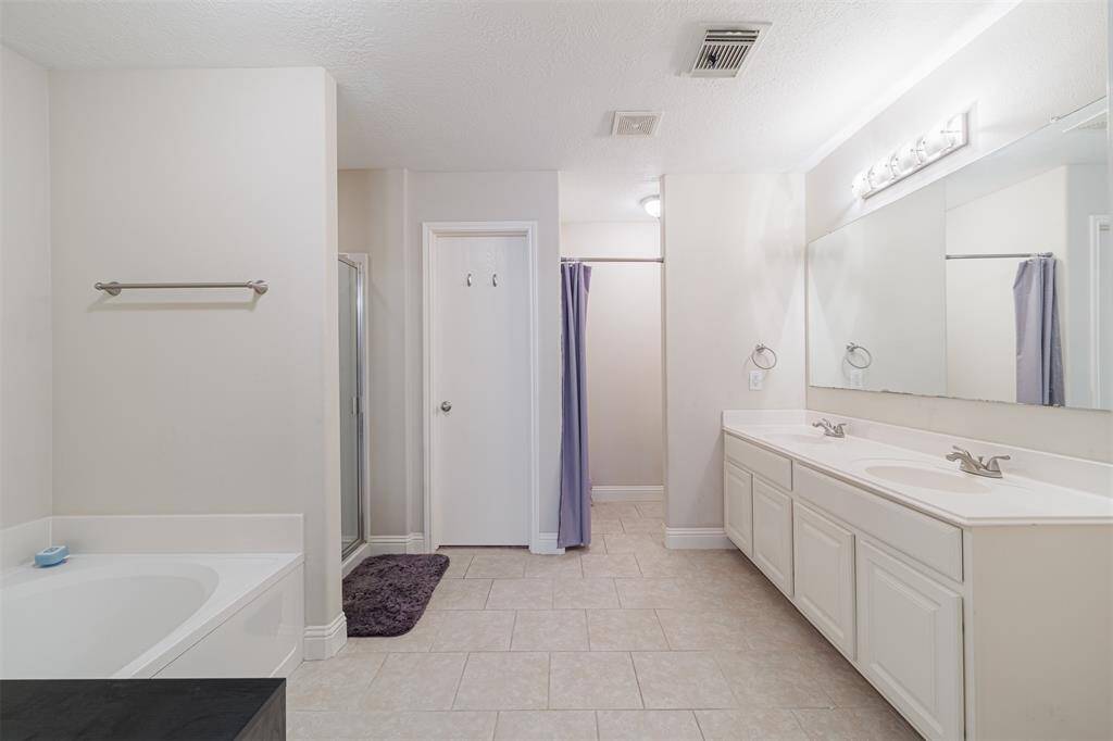 Primary bath with tile flooring garden tub and separate walk-in shower.