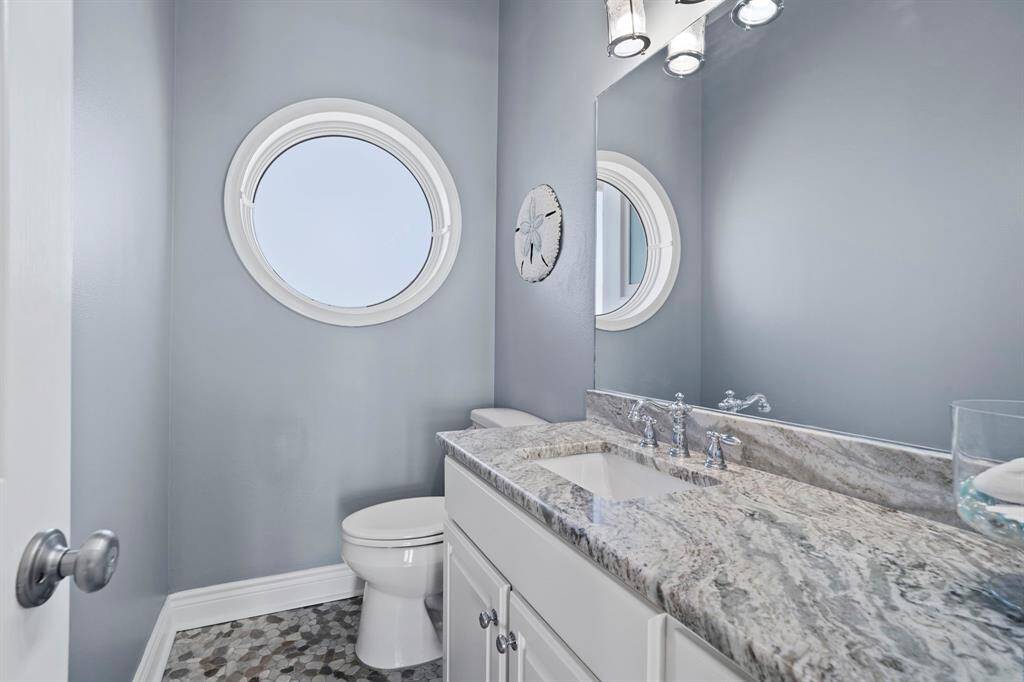 The half bathroom features white cabinets, spacious countertop, and tile floors. Located on 3rd floor off of living room area.