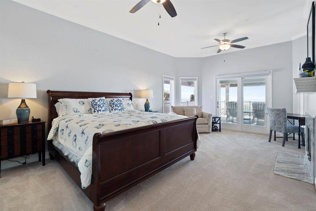 Second Primary Bedroom features large windows, plush carpet, cozy fireplace, and access to private balcony.