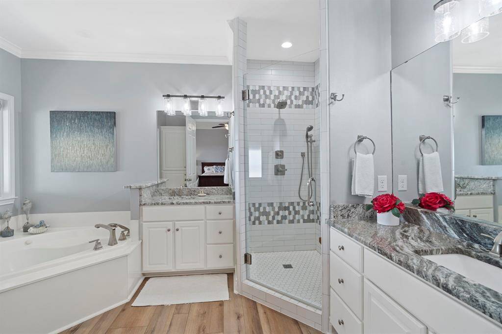 Secondary bathroom features walk-in shower with tile surround, dual sinks, and separate garden tub.