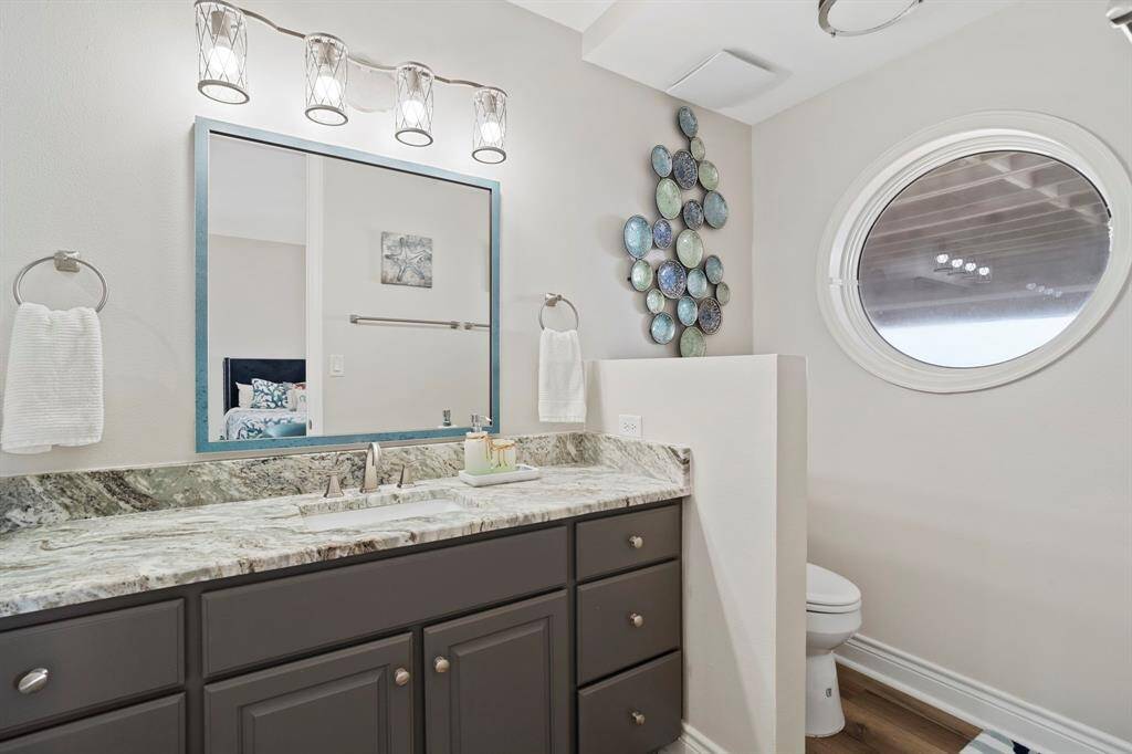 Ensuite bathroom features dark cabinets and spacious countertops and walk-in shower.