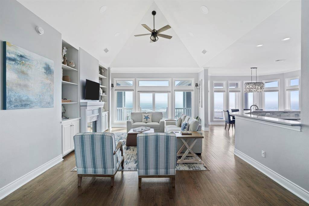 The living room features large windows, high ceilings, built-in shelving, and cozy fireplace.