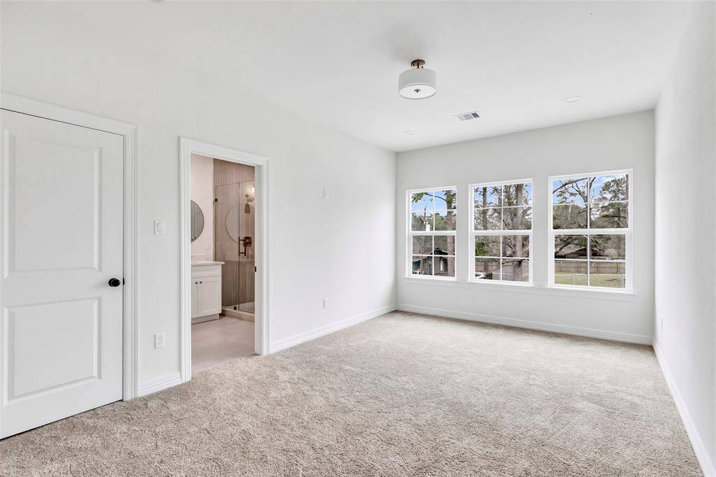 Elegant master bath with a double-sink vanity, private toilet, and a sleek frameless glass walk-in shower.