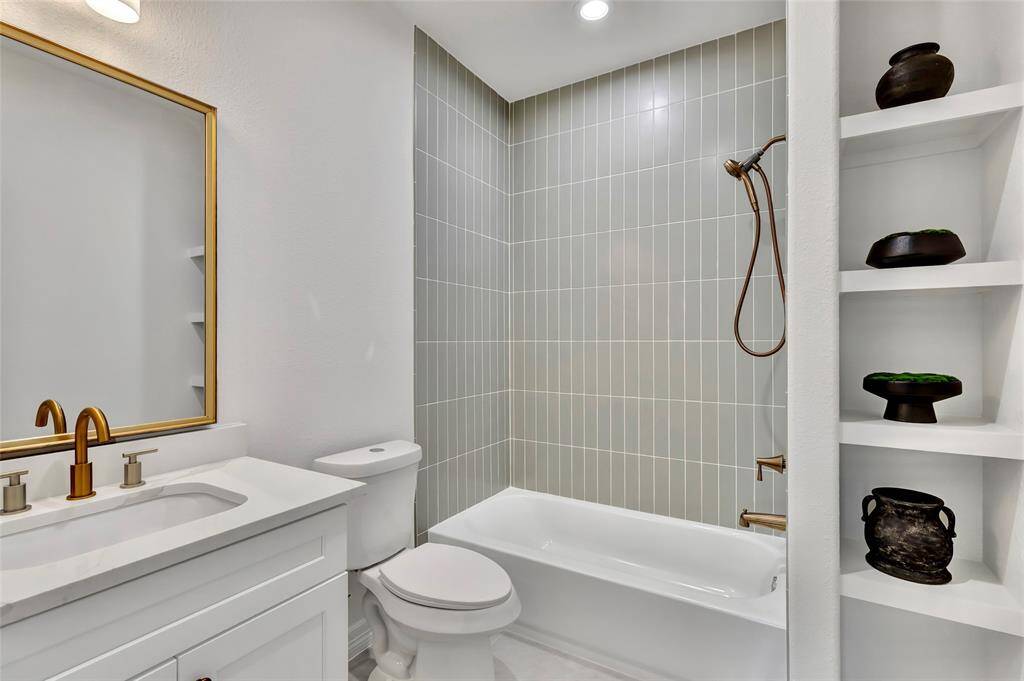 Spacious laundry room featuring convenient overhead shelving.