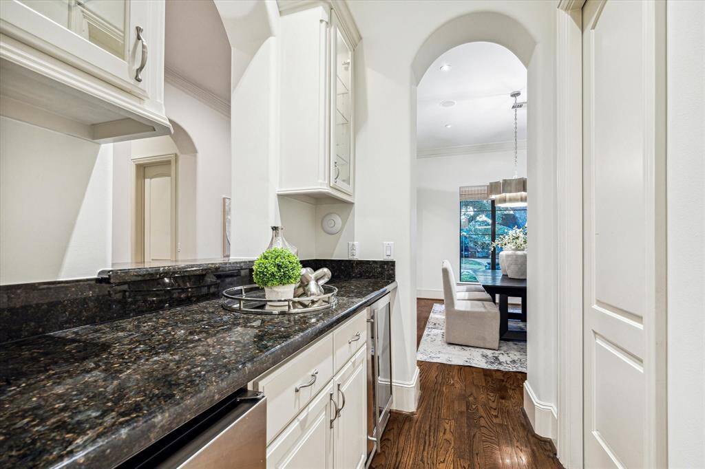 The butler’s pantry features a wine refrigerator, ice maker, and ample storage. To the right there is a walk-in pantry where all your organizational dreams can come true.