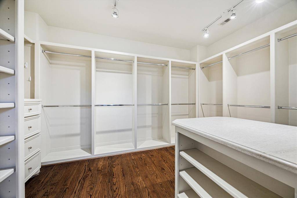 Spacious walk-in closet featuring built-ins for optimal organization and storage.