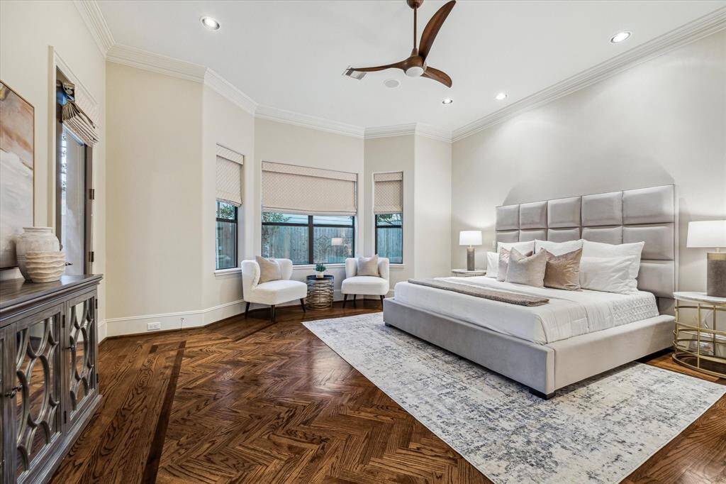 Large first floor primary suite with gorgeous wood inlay flooring in a herringbone pattern, bay window and direct access to the backyard, ceiling fan and recessed lighting.