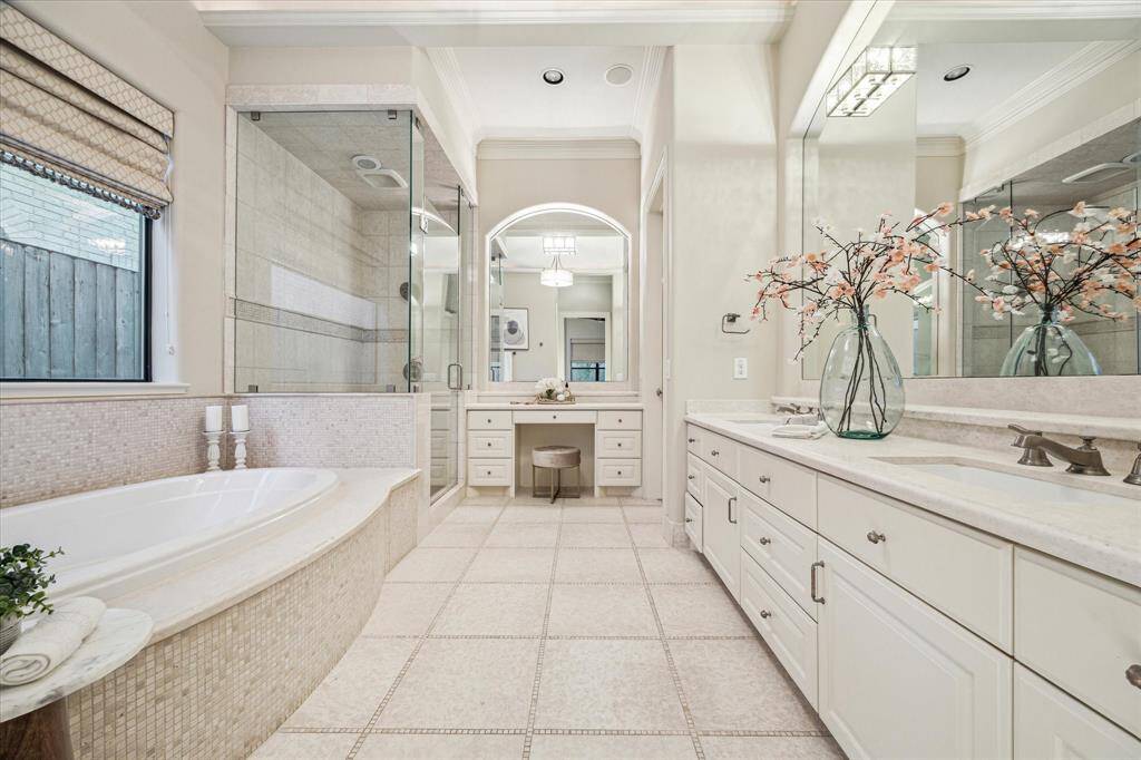 Ensuite bath with double sinks, glass enclosed shower, separate tub, and walk-in closet.