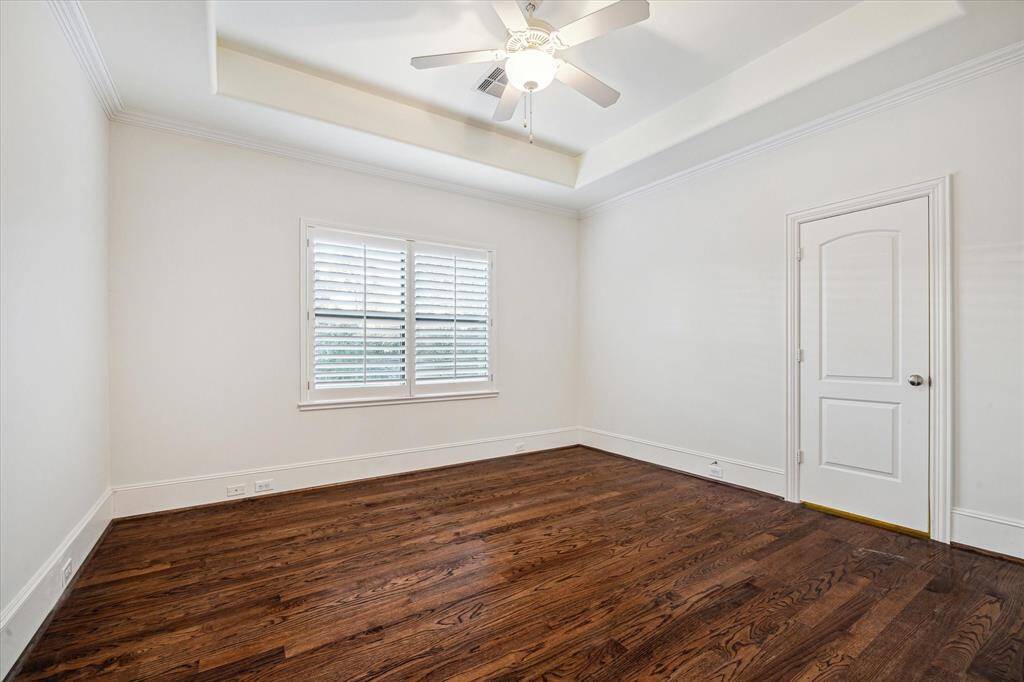 Secondary bedroom with hardwood floors, tray ceiling, walk-in closet and ensuite bathroom.