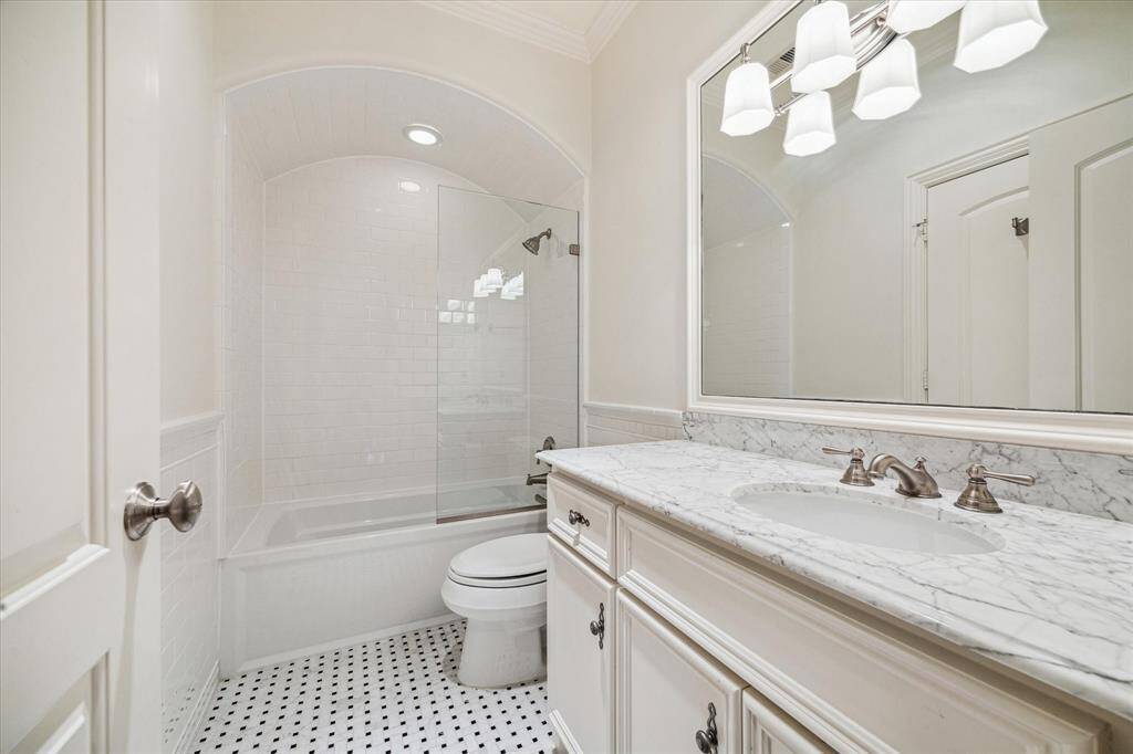 Ensuite bathroom with shower/tub combo and stylish tile.