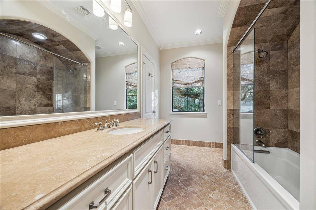 Ensuite bathroom with shower/tub combo and spacious countertop.
