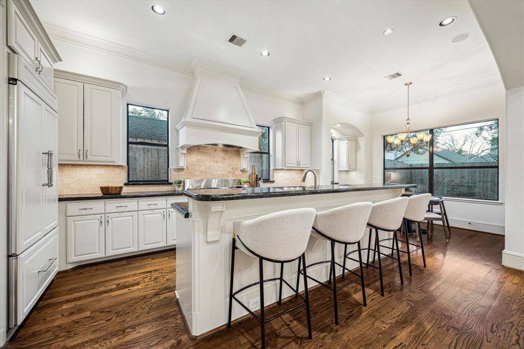The spacious kitchen is outfitted with high end appliances, breakfast bar, paneled refrigerator and overlooks the living room.