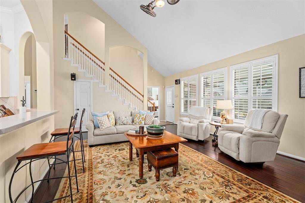 Upstairs features a spacious game room, along with all secondary bedrooms and a bath.This inviting living room features high vaulted ceilings, a cozy fireplace, and abundant natural light.