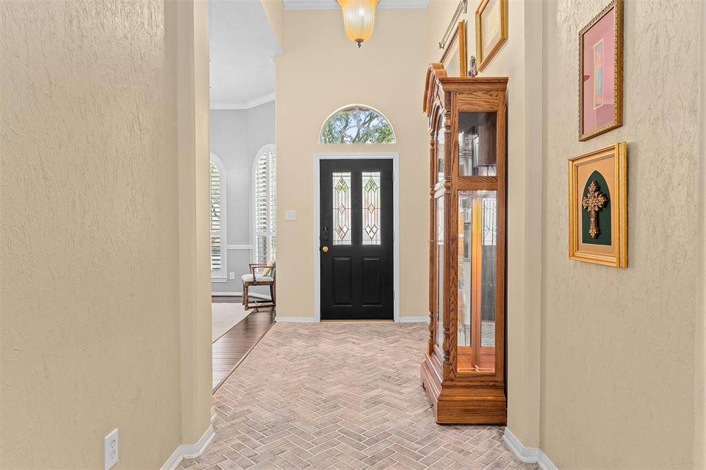 Step into this spacious entryway featuring elegant brick flooring and soothing neutral tones.