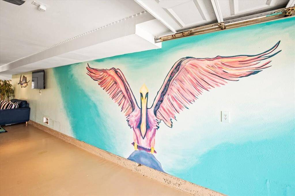 This is a room with an artistic touch, featuring an expansive wall mural of a colorful bird in flight, adding a vibrant and creative atmosphere to the space.