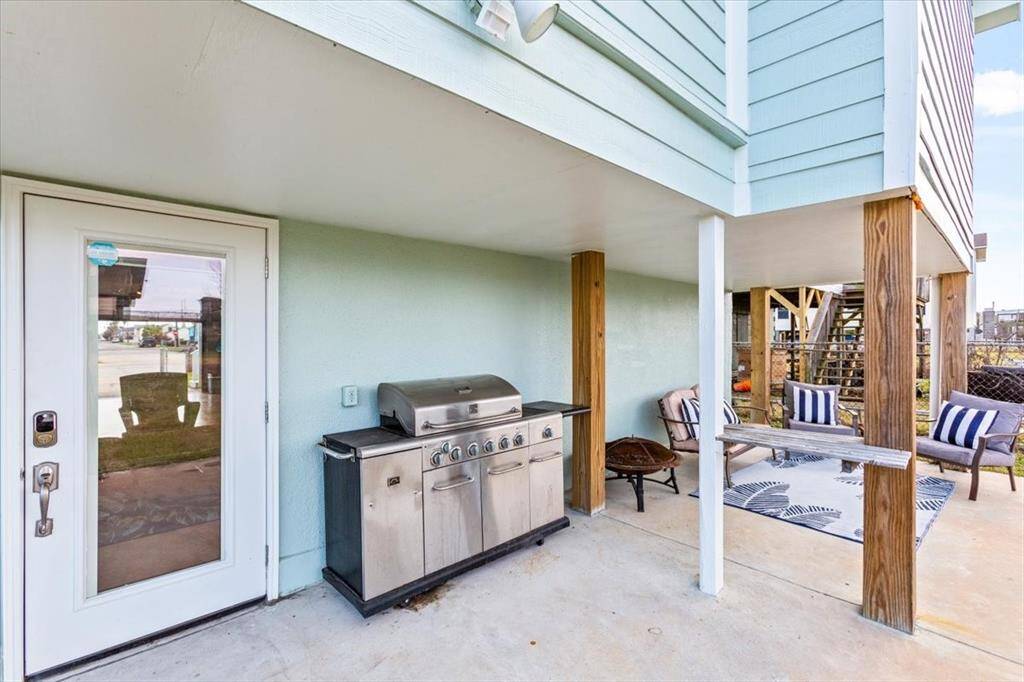 This is a cozy covered patio area featuring a barbecue grill, ideal for outdoor dining and entertaining.