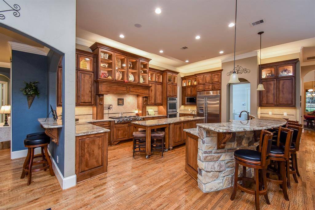 The kitchen is perfectly laid out to prepare for a crowd and features double ovens, a gas cooktop, large island, two sinks, a pot filler and huge pantry.