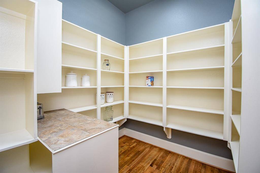 Pantry with prep counter and loads of shelving and storage.