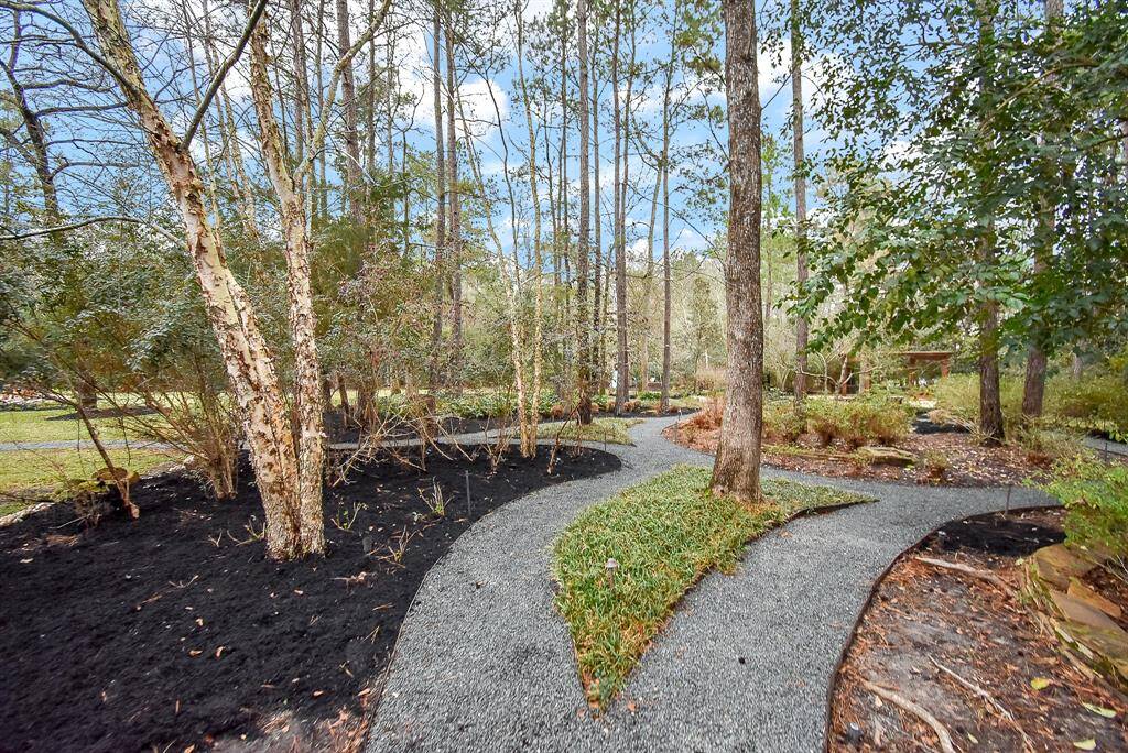 This yard has manicured pathways to the back of the property with a meditation bench, a hardscape area with a pergola and wood burning fire pit. Be sure to watch the video of the enchanting backyard!