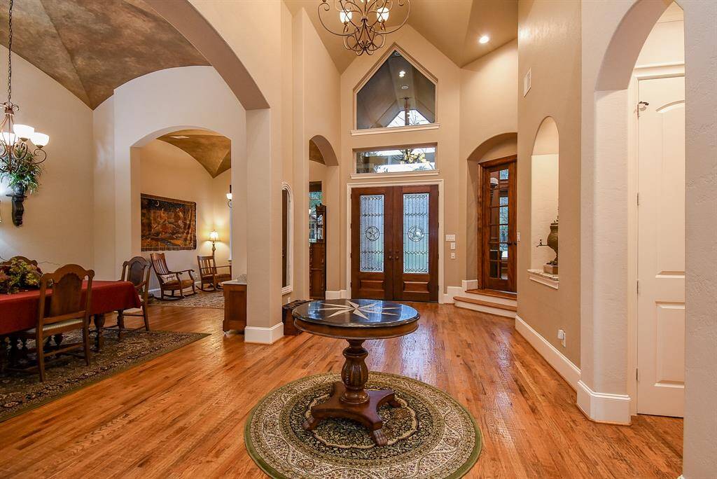 Inviting foyer with high ceiling and hand-scraped red oak wood flooring.