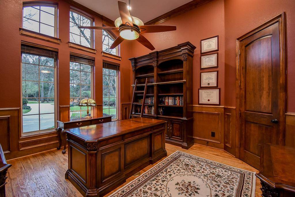 The stunning home office has ample space and overlooks the front yard.