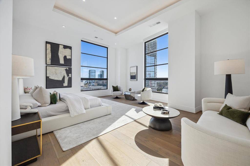 This magazine-worthy primary bedroom exudes luxury and tranquility, featuring two floor-to-ceiling windows that flood the space with natural light and offer captivating views.