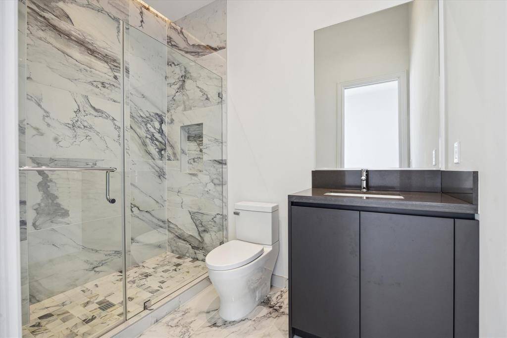 Both secondary bedrooms feature sleek ensuite baths with clean lines, high-end finishes, and sophisticated fixtures.