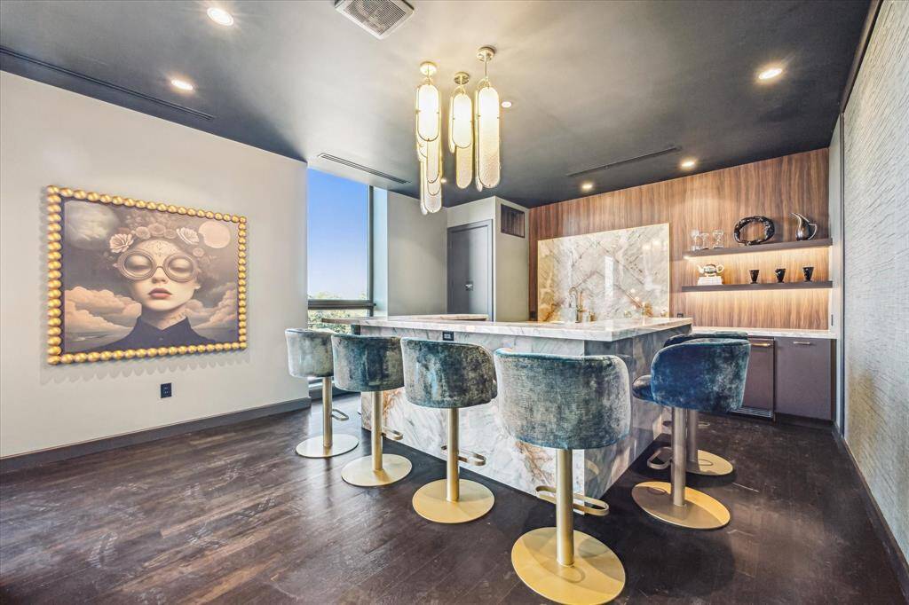 The sleek kitchen viewed in the background offers everything needed for entertaining. The room can be reserved for gatherings.