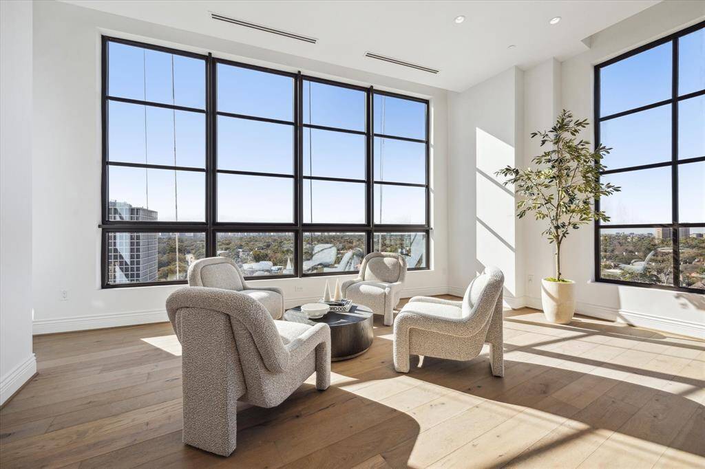 Wrapped in natural light, this intimate corner of the gathering room is framed by stunning floor-to-ceiling windows on two sides.. A perfect spot for morning coffee or evening conversation, this sophisticated sitting area invites you to relax while taking in the wraparound views.