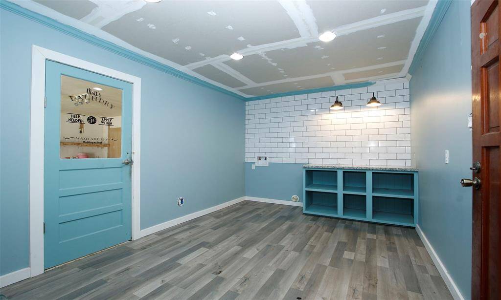 Room you enter from other side of the home which could be office space. The wall with the blue door has a room beyond it and the wall could be removed to offer 27' x 21' open space for Game Room or Spacious office space.