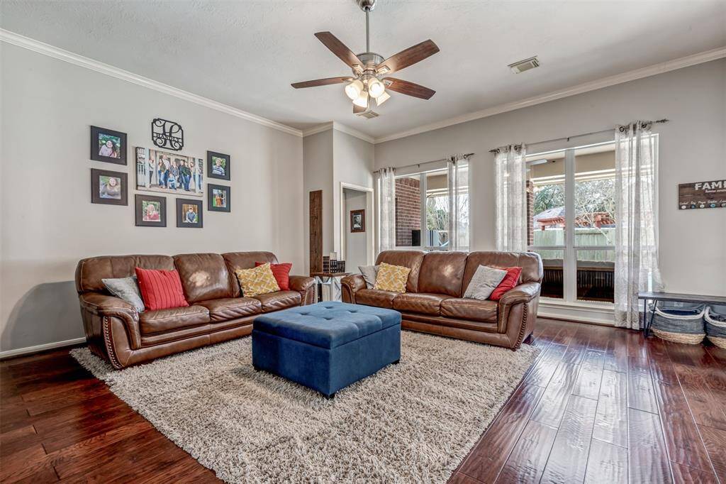 The main living room features an updated fan and crown moulding.