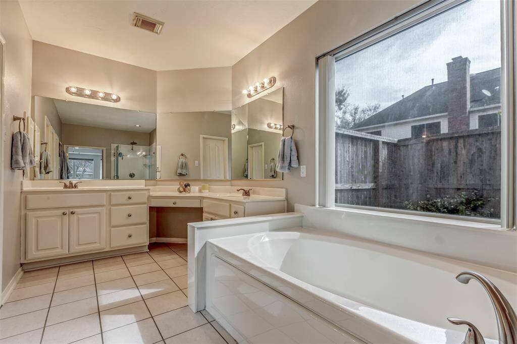 Dual sinks and middle vanity area. Privacy blinds included.
