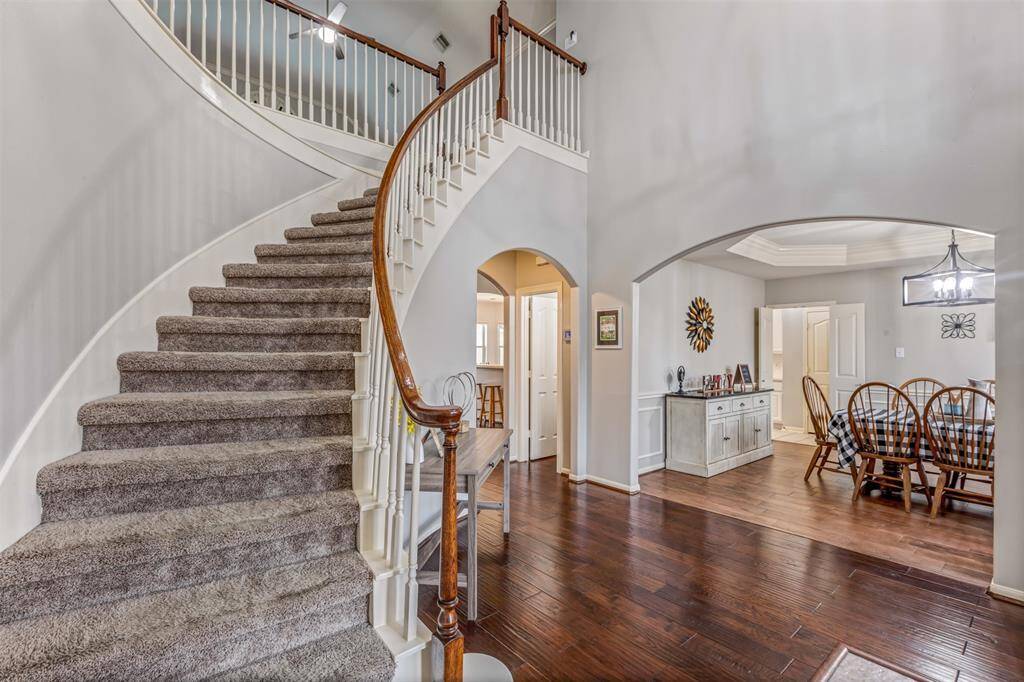 Rich hand scraped wood floors and this gorgeous curved staircase featured in this entry.
