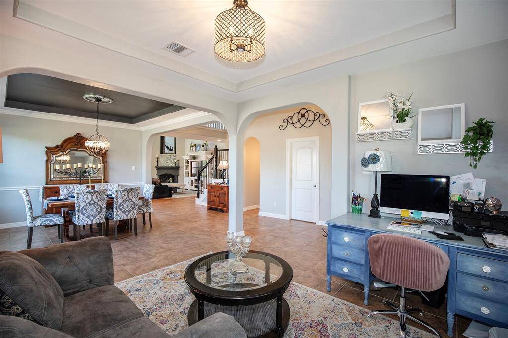 To the left of the entryway, the formal living and dining rooms offer a refined space for entertaining, featuring graceful archways and stylish finishes.