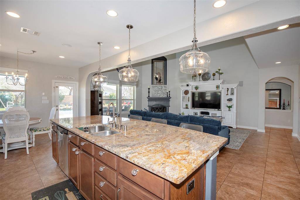 Custom lighting enhances the space, illuminating the sleek cabinetry and stylish backsplash while creating a warm and inviting ambiance.