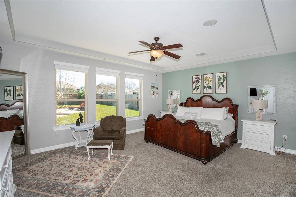 The primary bedroom has large windows with a fabulous view of the backyard and pool.