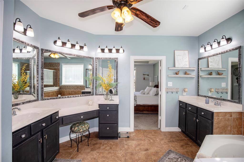 The luxurious primary bathroom offers a spa-like retreat, featuring two separate vanities that provide ample space and convenience.