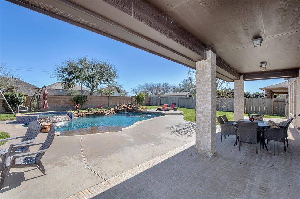 As you step out onto the covered patio, you are greeted with a marvelous backyard oasis.
