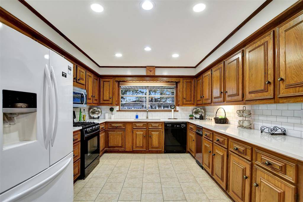 Beautiful kitchen with corian countertops and subway tile on backsplash